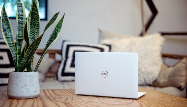 silver laptop on brown wooden table