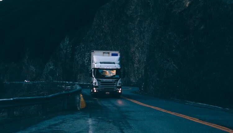 trailer truck passing on road near rail guard