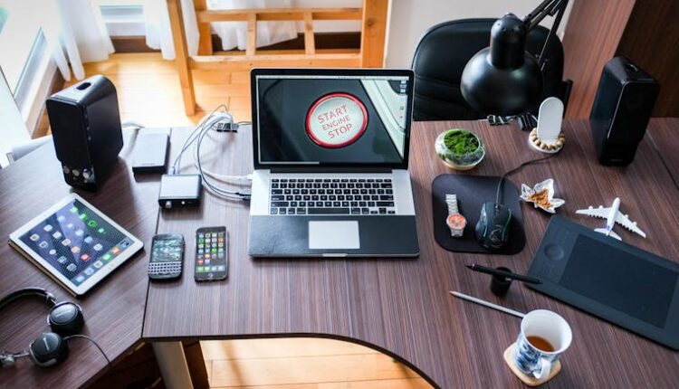 A contemporary office desk setup with laptops, gadgets, and accessories, creating a tech-savvy workplace.