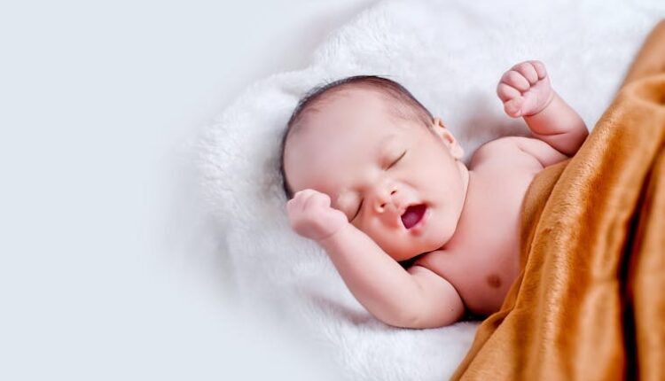 A peaceful sleeping infant wrapped in a soft, warm blanket on a cozy white surface.